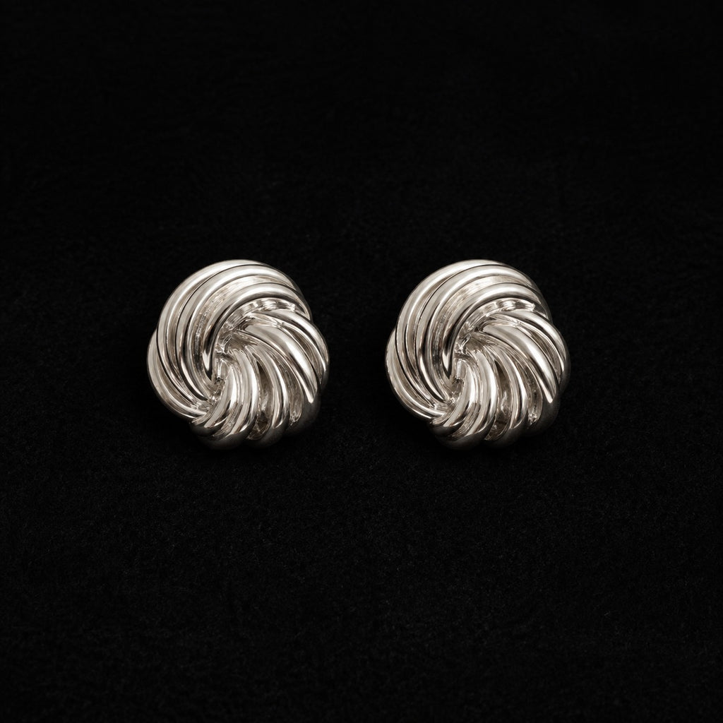 La Flaneuse silver stud earrings with a polished twisted knot design