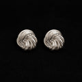 La Flaneuse silver stud earrings with a polished twisted knot design