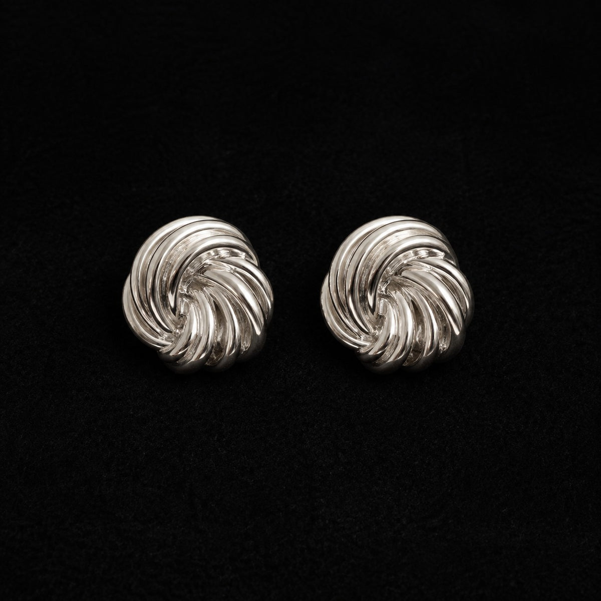 La Flaneuse silver stud earrings with a polished twisted knot design